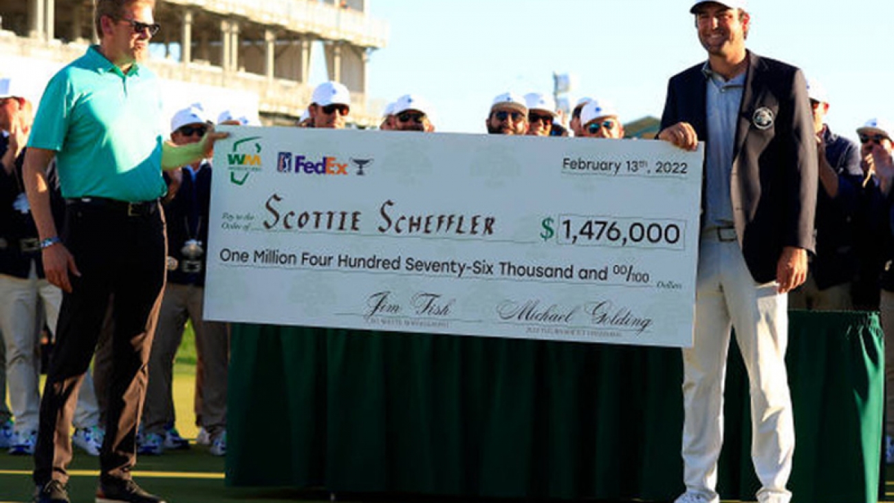 SCOTTSDALE, ARIZONA - FEBRUARY 13: President and Chief Executive Officer of Waste Management James Fish Jr. hands a check to Scottie Scheffler after winning the WM Phoenix Open at TPC Scottsdale on February 13, 2022 in Scottsdale, Arizona. (Photo by Mike Mulholland/Getty Images)